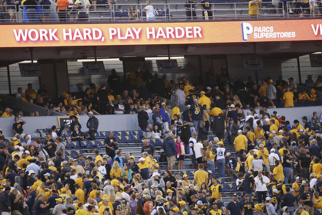 West Virginia fans head for the stadium concourse after the game was delayed due to severe weather during the first half against Duquesne on Saturday in Morgantown, W.Va.