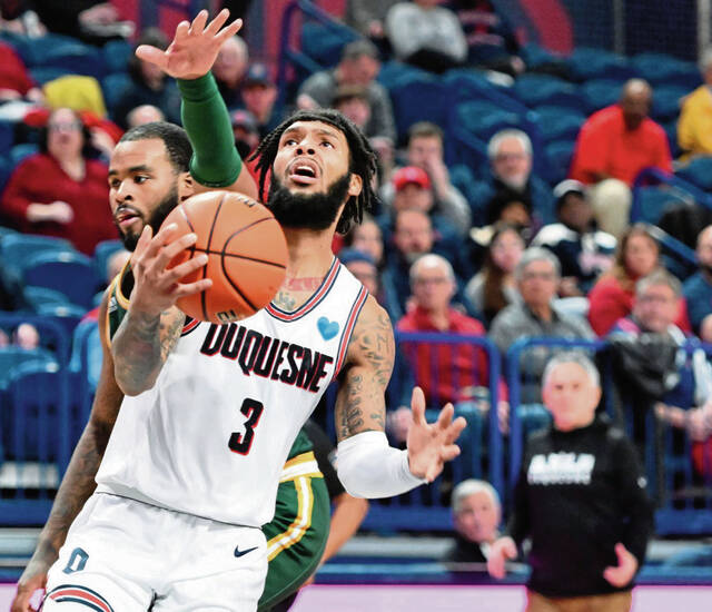 Duquesne’s Dae Dae Grant scores past George Mason’s DeVon Cooper in Feb. 8, at UPMC Cooper Fieldhouse.