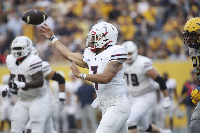 Duquesne quarterback Darius Perrantes (7) passes after a scramble during the first half of an NCAA football game against West Virginia, Saturday, Sept. 9, 2023, in Morgantown, W.Va.