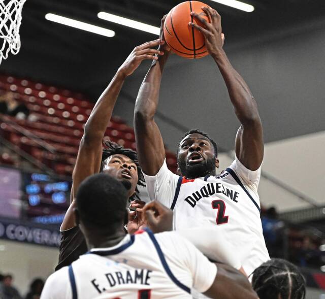 Duquesne’s David Dixon grabs a rebound over St. Bonaventure’s Barry Evans in the first half Tuesday at UPMC Cooper Fieldhouse.