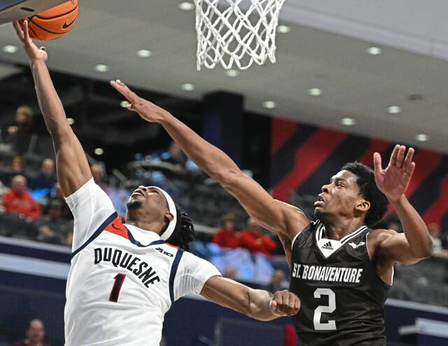 Duquesne’s Jimmy Clark III drives past St. Bonaventure’s Assa Essamvous in the second half of their Jan. 23 game at UPMC Cooper Fieldhouse.