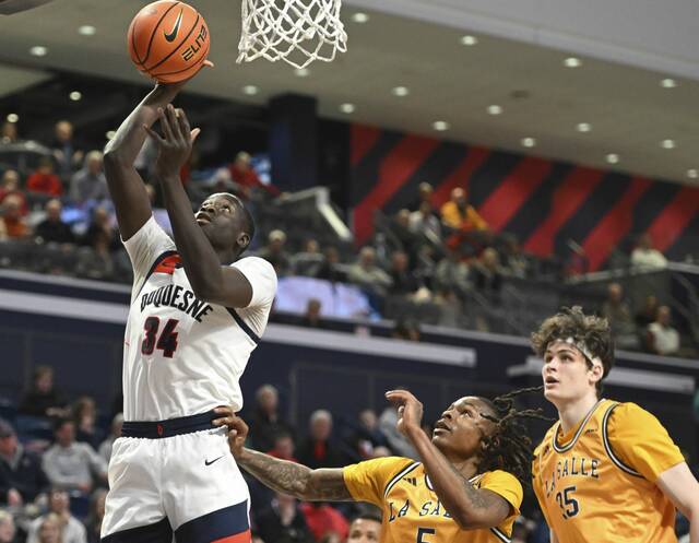 Duquesne’s Foussenyi Drame scores past La Salle’s Khalil Brantley last month.