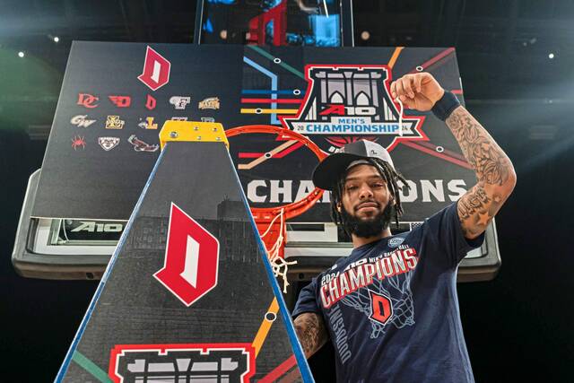 Duquesne’s Dae Dae Grant poses with a piece of net after beating VCU in the championship of the Atlantic 10 Tournament on Sunday in New York.