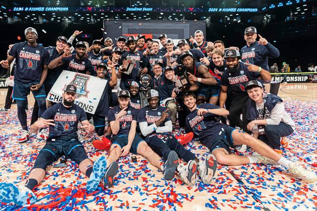 Duquesne players and team staff pose after an NCAA college basketball game against Virginia Commonwealth in the championship of the Atlantic 10 Conference tournament Sunday, March 17, 2024, in New York.