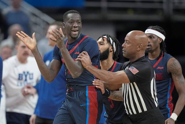 Duquesne forward Fousseyni Drame (34) is is pushed away by an official after a scuffle in the second half of a first-round college basketball game against BYU in the NCAA Tournament, Thursday, March 21, 2024, in Omaha, Neb. (AP Photo/Charlie Neibergall)