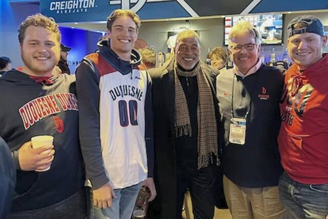 Former Duquesne and NBA basketball star Norm Nixon, Duquesne University President Ken Gormley, and a couple of unidentified fans inside CHI Health Center in Omaha, Neb. where Duquesne upset BYU Thursday.