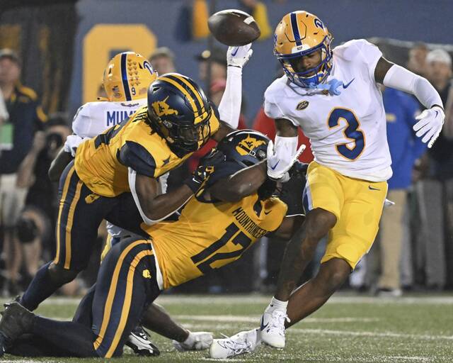 West Virginia’s Malachi Ruffin and Anthony Wilson (12) defend on a pass intended for Pitt’s Daejon Reynolds in the fourth quarter Sept. 16, 2023, at Mountaineer Field.