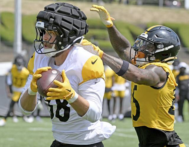 Pittsburgh Steelers tight end Pat Freiermuth pulls in a pass in front of coverage by safety DeShon Elliott during Friday’s training-camp practice at Saint Vincent College.