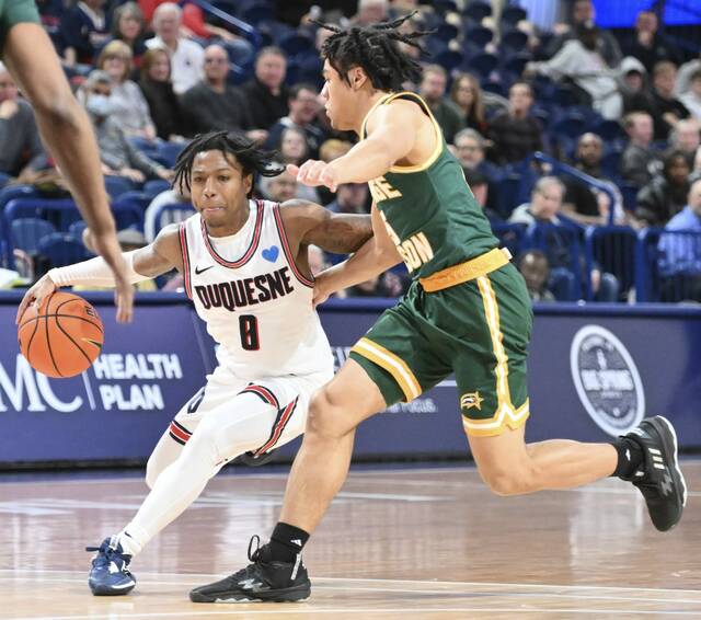 Duquesne’s Tevin Brewer drives past George Mason’s Devin Dinkins in February 2023 at UPMC Cooper Fieldhouse.