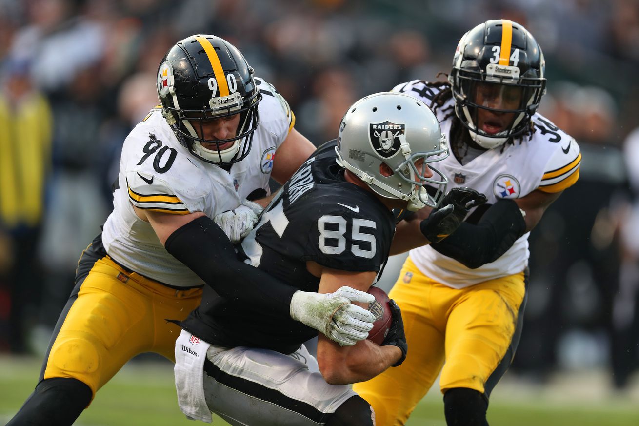 Pittsburgh Steelers defenders T.J. Watt and Terrell Edmunds assist each other in tackling Las Vegas Raiders tight end Derek Carrier during a 2018 regular season contest.