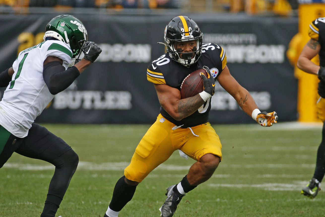 Pittsburgh Steelers running back Jaylen Warren rushes downfield against a New York Jets defender during a 2022 regular season contest from Acrisure Stadium.