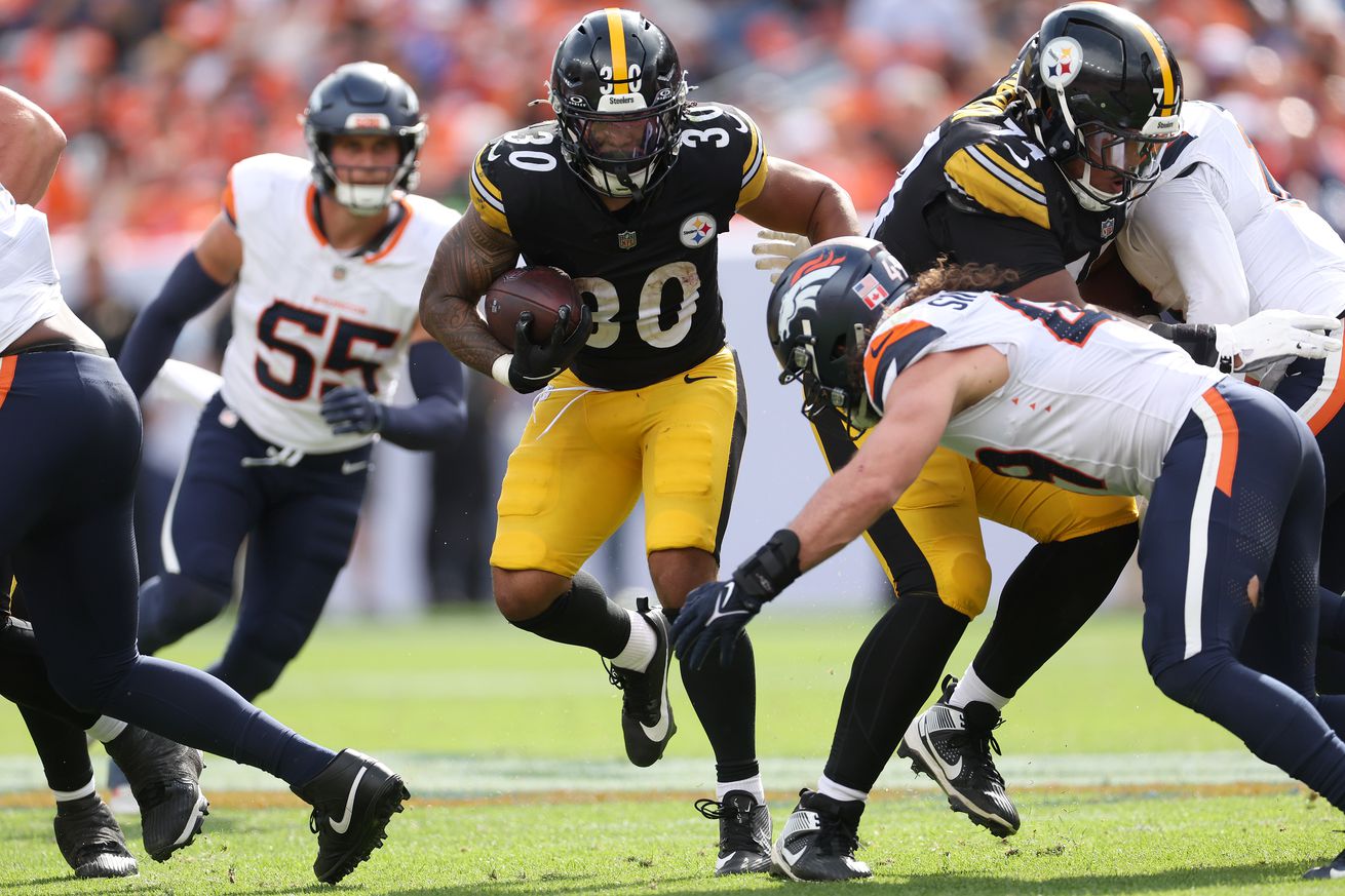 Jaylen Warren #30 of the Pittsburgh Steelers carries the ball against Alex Singleton #49 of the Denver Broncos in the second quarter at Empower Field At Mile High on September 15, 2024 in Denver, Colorado.