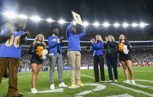 Former Pitt player Larry Fitzgerald is presented a plaque Thursday recognizing his selection to the College Hall of Fame.