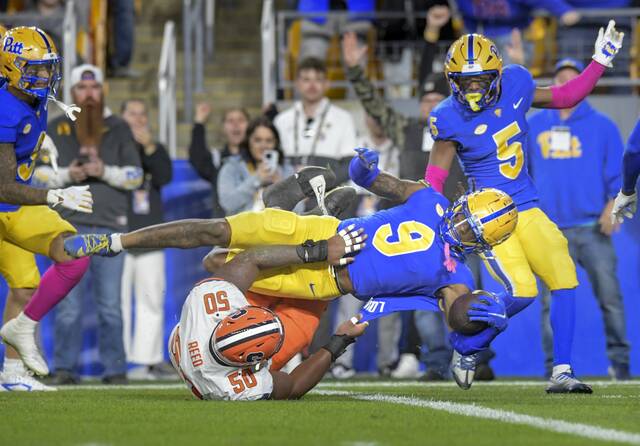 Pitt’s Kyle Louis is tackled by Syracuse’s J’Onre Reed after returning an interception for a touchdown in the first half Thursday.