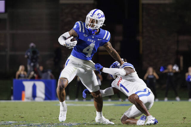 Duke’s Eli Pancol (4) carries the ball as SMU’s Brandon Crossley (1) attempts a tackle on Saturday, during the second half of an NCAA college football game in Durham, N.C.