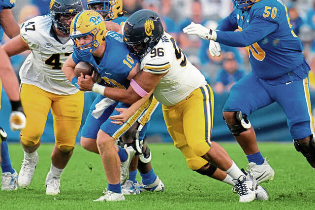 Pittsburgh quarterback Eli Holstein (10) is tackled by California defensive lineman Derek Wilkins (96) after a short gain during the second half of an NCAA college football game, Saturday, Oct. 12, 2024, in Pittsburgh. Pittsburgh won 17-15. (AP Photo/Gene J. Puskar)