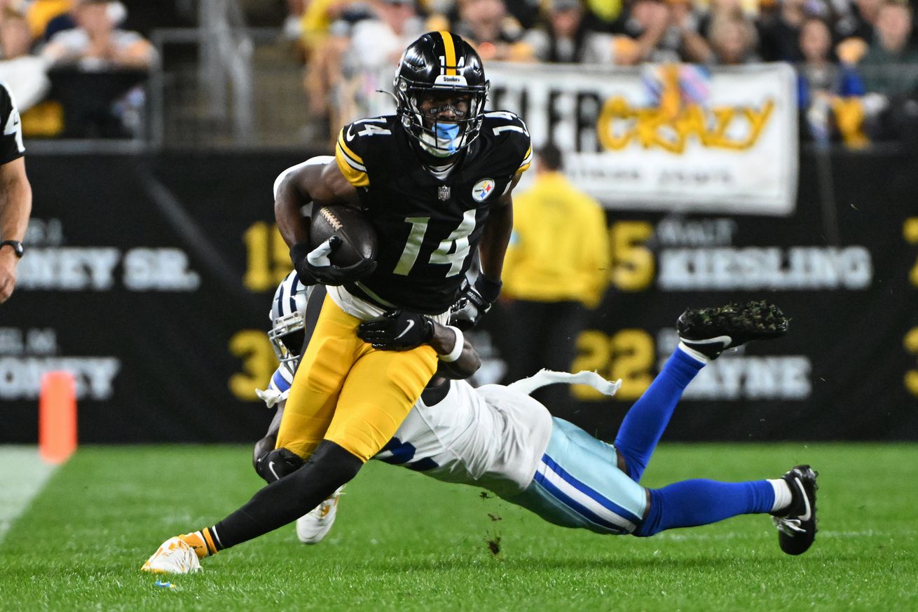 Pittsburgh Steelers wide receiver George Pickens (14) breaks a tackle by Dallas Cowboys cornerback Jourdan Lewis (2) during the first quarter at Acrisure Stadium. Mandatory Credit: Barry Reeger-Imagn Images   