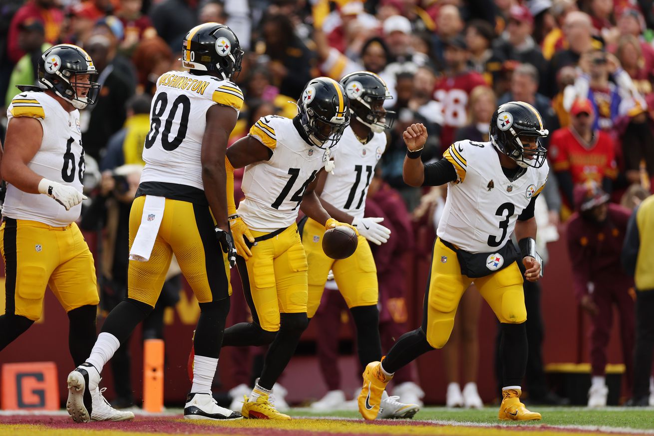 George Pickens #14 and Russell Wilson #3 of the Pittsburgh Steelers celebrate after Pickens’ receiving touchdown in the first quarter of a game against the Washington Commanders at Northwest Stadium on November 10, 2024 in Landover, Maryland.