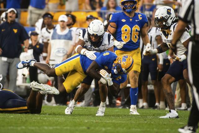 Pitt’s Konata Mumpfield makes a catch but is tackled by West Virginia’s Rodney Gallagher III in the fourth quarter earlier this season.