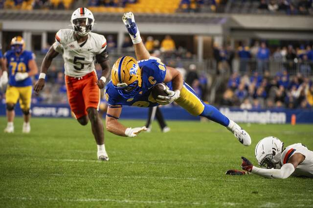 Pitt’s Gavin Bartholomew leaps to avoid a Virginia tackle on Saturday at Acrisure Stadium.