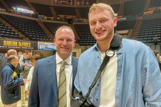 West Virginia coach Darian DeVries poses with his son, Tucker, during an introductory news conference in March.