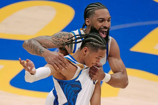 Pitt’s Damian Dunn and Jaland Lowe celebrate at the end of the first half against West Virginia on Friday.