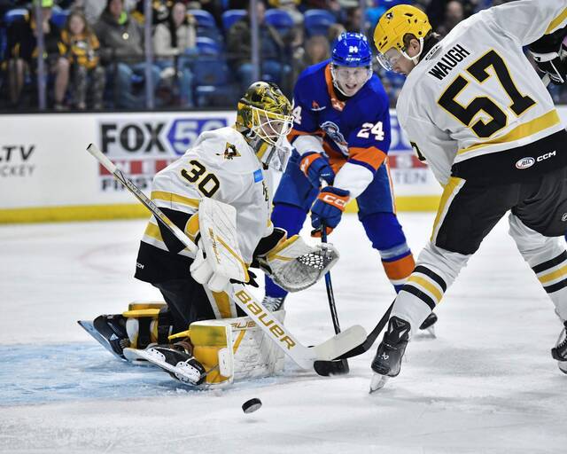 Wilkes-Barre/Scranton Penguins goaltender Joel Blomqvist defends his net as Bridgeport Islanders forward Fredrik Karlstrom and Penguins defenseman Philip Waugh surround the crease during a game at Mohegan Sun Arena in Wilkes-Barre on Saturday. The Islanders won, 5-2.