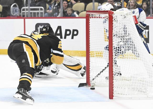 Tampa Bay Lightning forward Brayden Point puts in the game-winning goal from behind the net as Matt Grzelcyk defends to beat the Penguins, 3-2, in overtime Tuesday Nov. 19, 2024 at PPG Paints Arena.