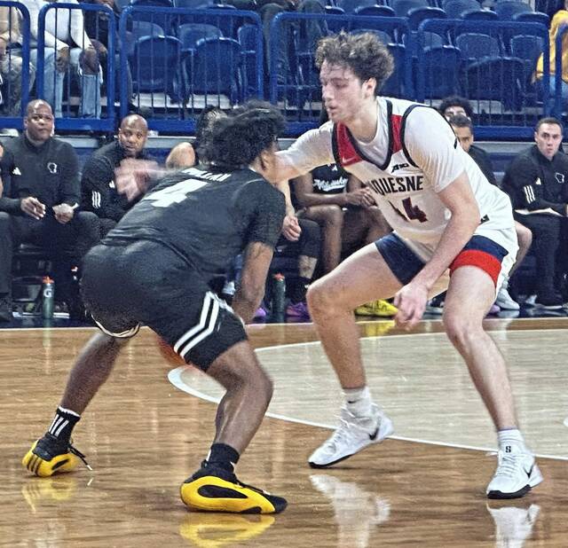 Duquesne’s Jake DiMichele guards Milwaukee’s Kentrell Pullian on Tuesday at UPMC Cooper Fieldhouse.