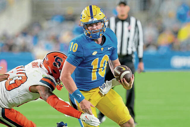 Pitt quarterback Eli Holstein escapes from Syracuse defensive back Devin Grant during the first half Oct. 24.