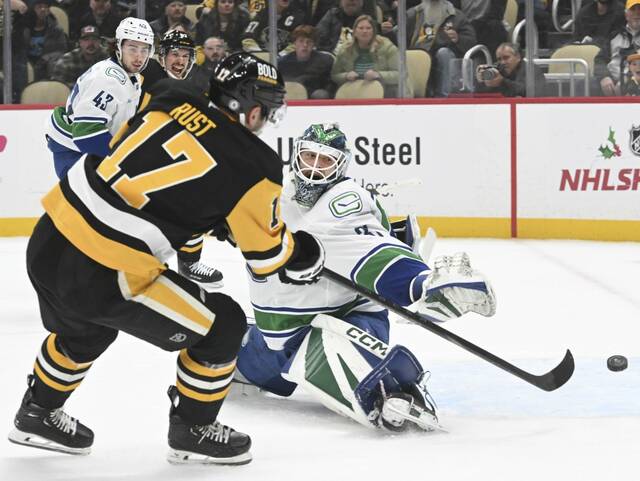 The Penguins’ Bryan Rust beats Canucks goaltender Artus Silovs in the first period Wednesday at PPG Paints Arena.