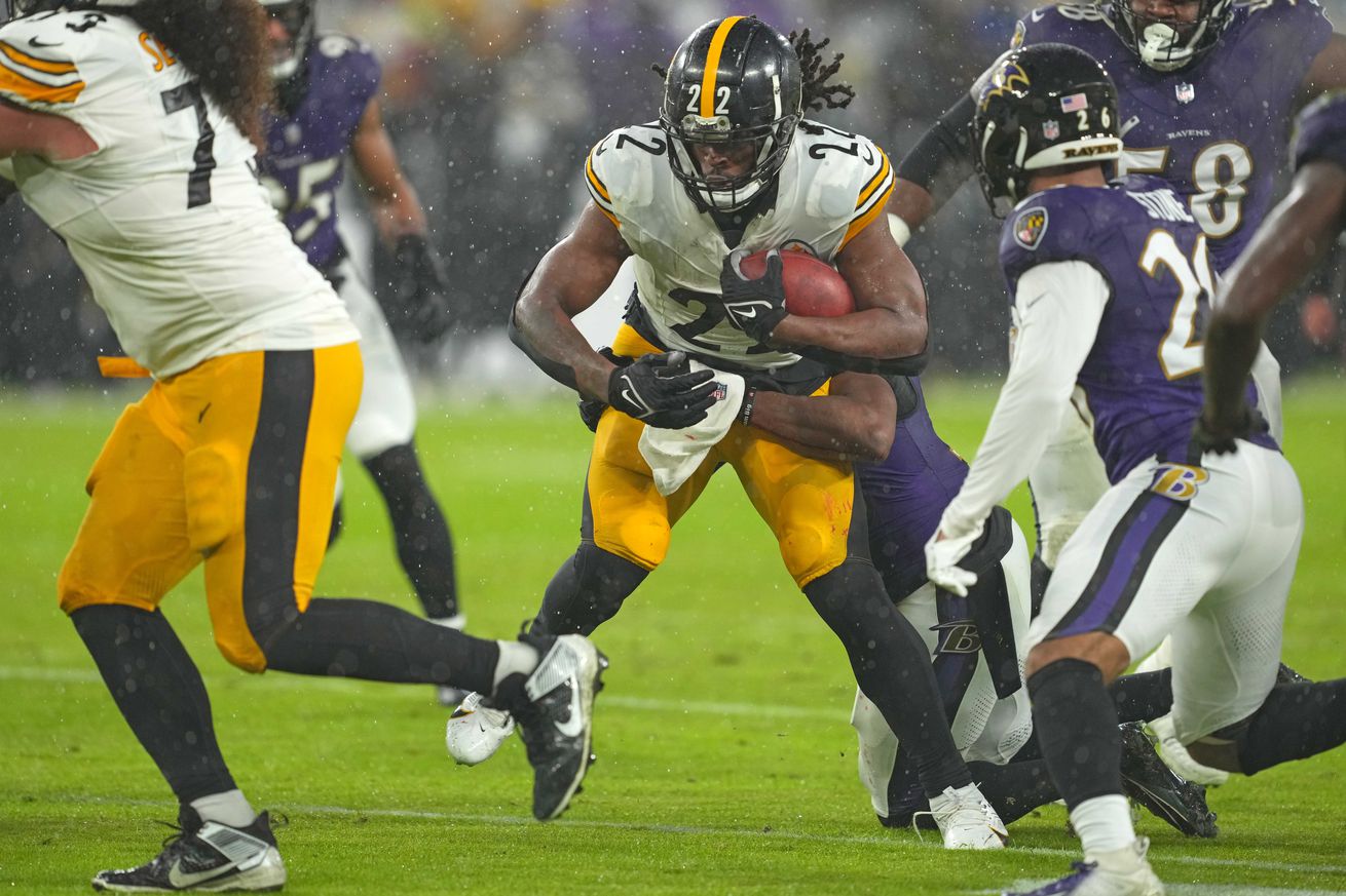 Pittsburgh Steelers running back Najee Harris barrels through Baltimore Ravens defenders during a 2023 NFL regular season contest from Baltimore.