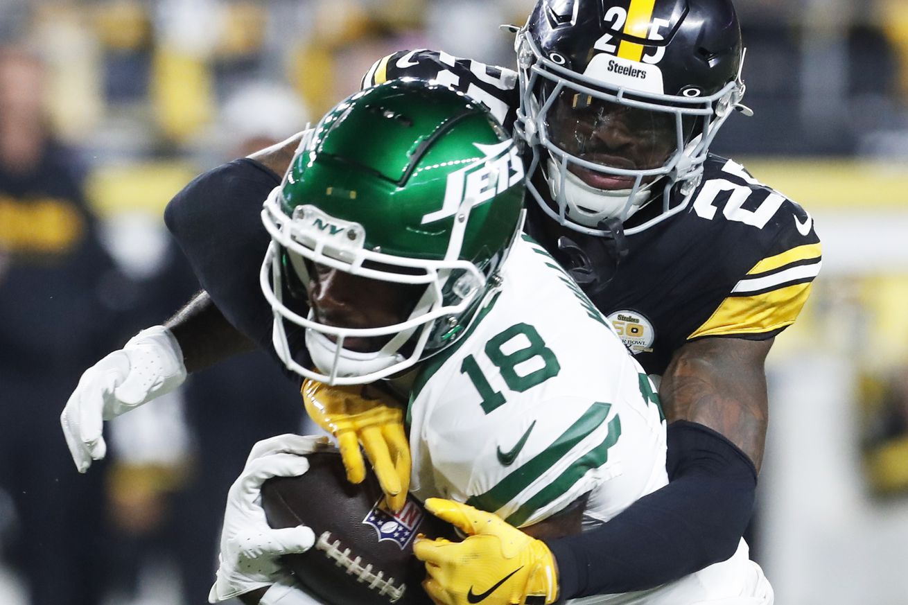 New York Jets wide receiver Mike Williams fights through a tackle from Pittsburgh Steelers defender DeShon Elliott during a 2024 regular season contest from Acrisure Stadium.