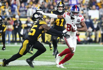 New York Giants wide receiver Darius Slayton fends off Pittsburgh Steelers safety DeShon Elliott as he trots upfield during a 2024 regular season contest.