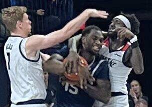 St. Peter’s Stephon Roberts is boxed in by Duquesne’s Jakub Necas (left) and Chabi Barre during the first half Tuesday.