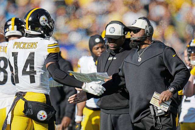 Steelers head coach Mike Tomlin celebrates Dec. 18, 2022, with wide receiver George Pickens during the first half against the Carolina Panthers in Charlotte, N.C.