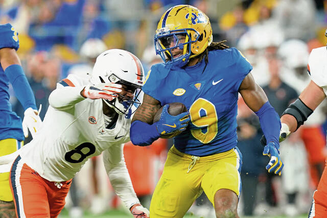 Pittsburgh linebacker Kyle Louis (9) carries after intercepting a ball as he’s defended by Virginia wide receiver Malachi Fields (8) during the first half of an NCAA college football game Saturday, Nov. 9, 2024, in Pittsburgh. (AP Photo/Matt Freed)