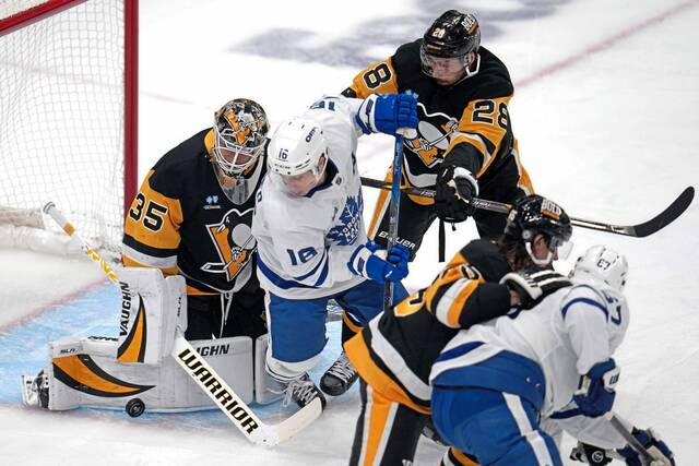 Toronto Maple Leafs’ Mitch Marner (16) is defended by Pittsburgh Penguins’ Marcus Pettersson (28) in front of goaltender Tristan Jarry (35) during the first period of an NHL hockey game Saturday, Dec. 7, 2024, in Pittsburgh.