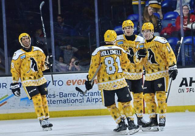 Wilkes-Barre/Scranton Penguins forward Marc Johnstone (No. 9), defenseman Mac Hollowell, forward Joona Koppanen (No. 15) and forward Corey Andonovski celebrate a goal during a 7-2 win against the Lehigh Valley Phantoms at Mohegan Sun Arena in Wilkes-Barre on Saturday.