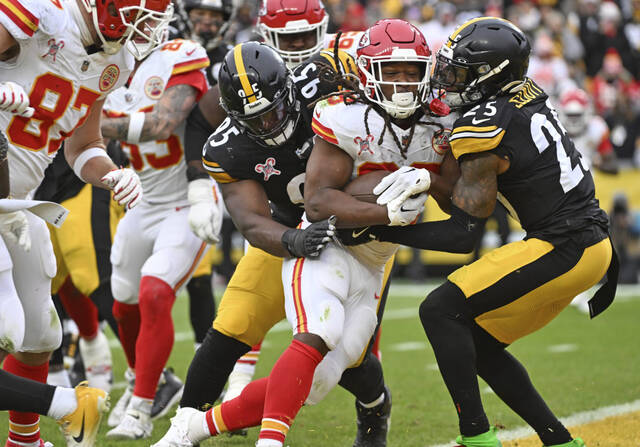 Chiefs running back Kareem Hunt plows into the end zone Wednesday against the Steelers’ Keeanu Benton and DeShon Elliott in the fourth quarter at Acrisure Stadium.