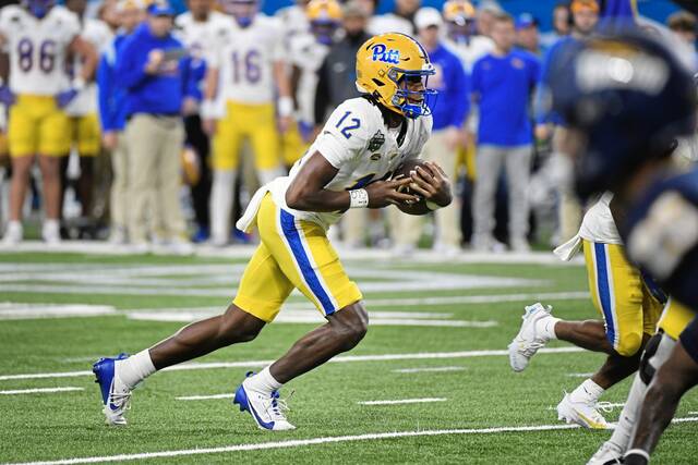 Pitt quarterback Julian Dugger runs with the ball against Toledo during the first half of the GameAbove Sports Bowl on Thursday in Detroit.