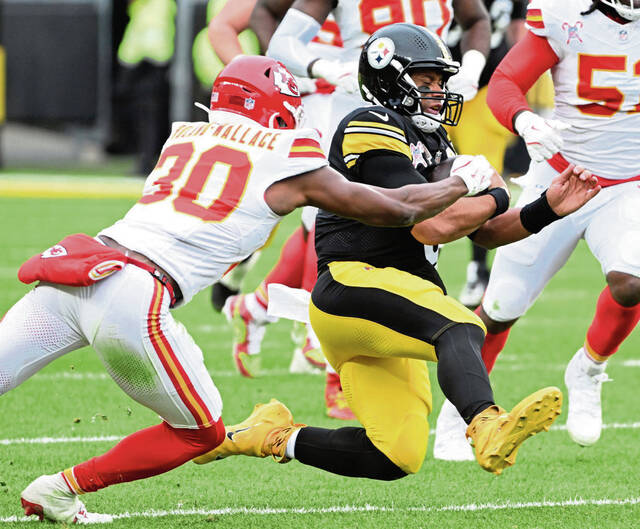 Steelers quarterback Russell Wilson slides past the Chiefs’ Chris Roland-Wallace in the third quarter Dec. 25, 2024 at Acrisure Stadium.