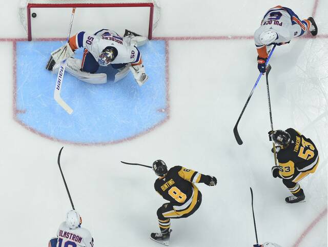 The Penguins’ Michael Bunting beats Islanders goaltender Marcus Hogberg in the second period Dec. 29, 2024, at PPG Paints Arena.