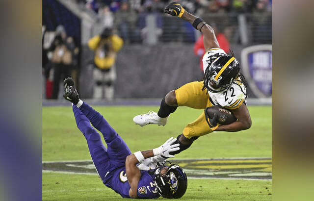 The Ravens’ Ar’Darius Washington takes out Steelers running back Najee Harris in the third quarter of the Dec. 21 game at M&T Bank Stadium.