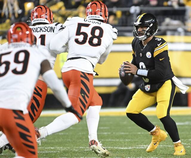 The Bengals’ Trey Hendrickson and Joseph Ossai pressure Steelers quarterback Russell Wilson in the second quarter Saturday, Jan. 4, 2025 at Acrisure Stadium.