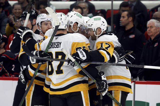 Penguins players celebrate a goal by Michael Bunting during the first period against the Hurricanes on Sunday.