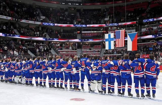 United States’ players embrace during the anthems after winning the IIHF World Junior Hockey Championship gold medal game in Ottawa on Sunday.