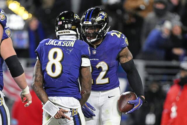 Ravens running back Derrick Henry celebrates his touchdown run with quarterback Lamar Jackson during the second half against the Browns on Saturday.