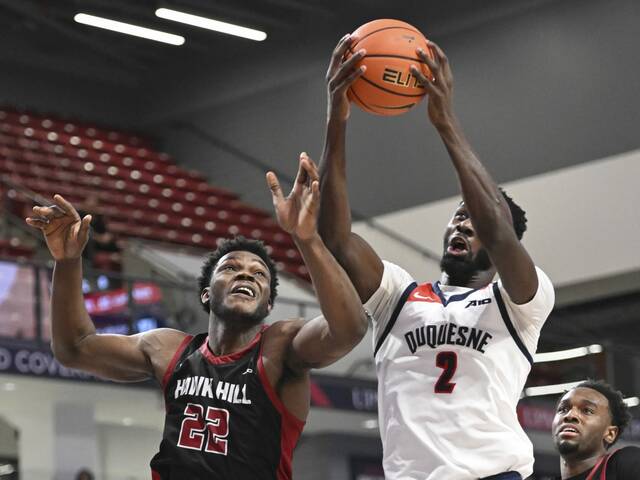 Duquesne’s David Dixon grabs a rebound over Saint Joseph’s Justice Ajogbor in the first half Wednesday.