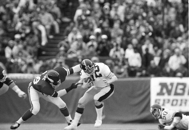 Pittsburgh Steelers’ quarterback Terry Bradshaw (12) is caught and thrown for a loss by Vikings’ tackle Alan Page during the first quarter of Super Bowl IX, Jan. 12, 1975, in New Orleans.